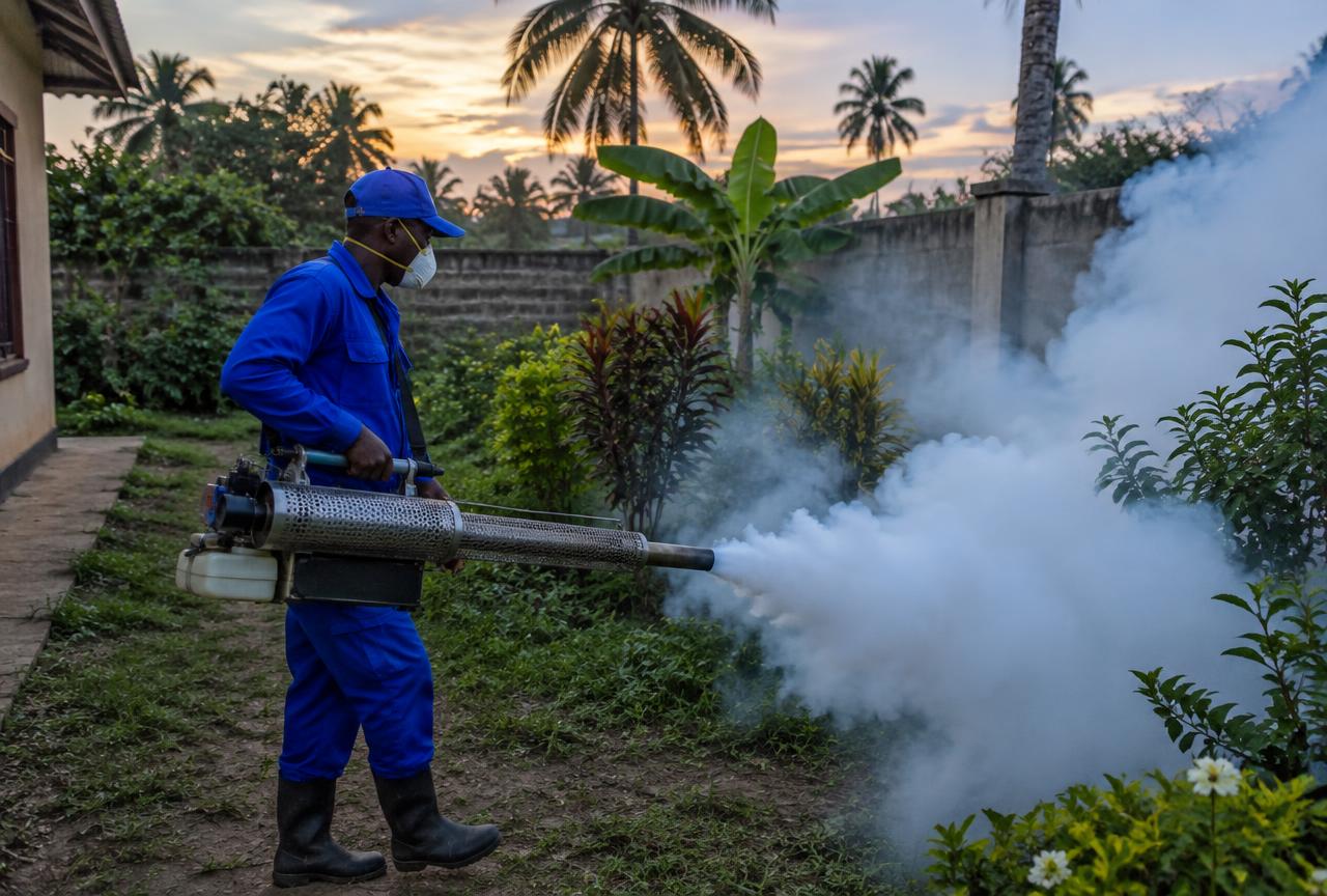 Technician fogging a garden compound for mosquitoes in Mbezi Beach, Dar es Salaam